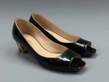 a pair of black heels with gold accents on the toes