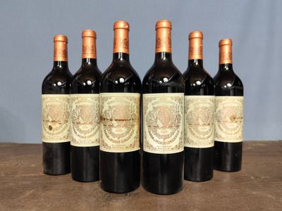 six bottles of wine are lined up on a wooden table