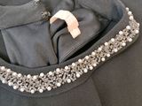 the back of a black dress with pearls and pearls on it
