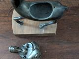 a small bird statue on a wooden block next to a spoon