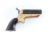 un vieux revolver avec un manche en bois sur fond blanc