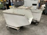 two white bins sitting on top of a dolly in a warehouse