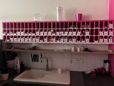 une étagère rose au-dessus d'un évier dans une cuisine