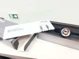une montre en argent posée sur une boîte, elle-même posée sur un bureau