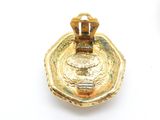 a gold plate with a ring on it on a white surface
