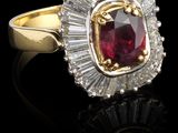 gros plan d'une bague avec une pierre rouge entourée de diamants blancs
