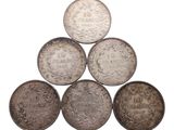 six pièces d'argent disposées en pyramide sur un fond blanc