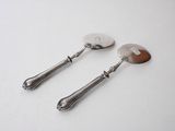 two silver spoons and a spoon on a white surface