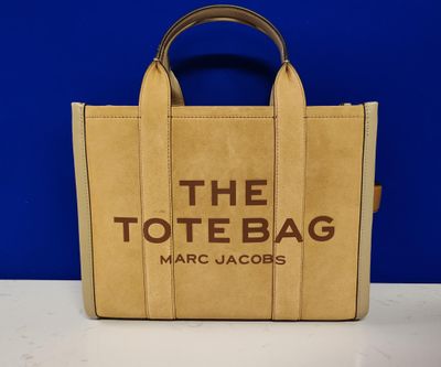 a tan tote bag with the tote bag marc jacobs logo on it