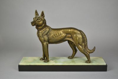 statue en bronze représentant un chien, posée sur un socle en marbre, sur fond gris