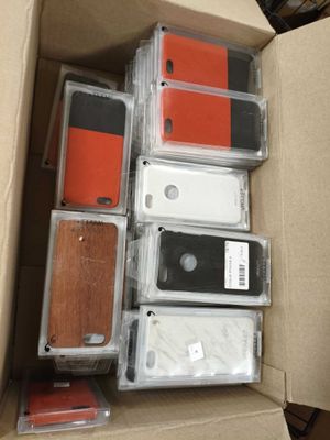 beaucoup de téléphones portables dans une boîte posée par terre
