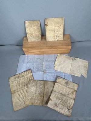 quelques vieux papiers et un support en bois posés sur une table