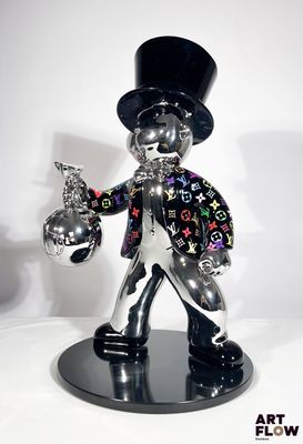une statue représentant un homme coiffé d'un haut-de-forme et tenant un pistolet