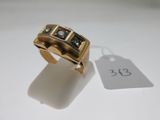 an image of a gold ring with black and white stones
