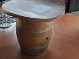 a table made out of a wine barrel on the floor