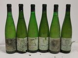 six bottles of wine are lined up in a row on a table