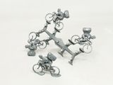 three miniature figurines of people riding bicycles