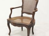 an antique chair with cane back and cane seat in a white room