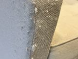 a close up of a white couch with holes in it