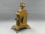 a gold clock with a bird on top of it