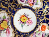 a blue plate with flowers on it next to a cup and saucer