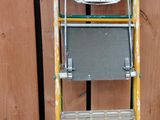 une échelle sur laquelle est posé un ordinateur, dans une pièce