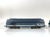a blue and white train on the tracks next to a black and white train car