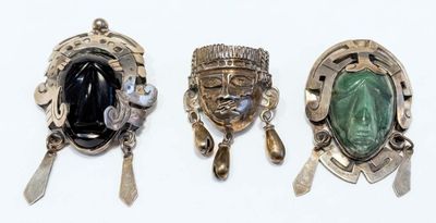 trois broches en argent et en jade et une paire de cuillères en argent