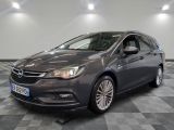 L'Opel grise est garée dans une grande pièce au sol carrelé.