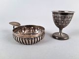 une coupe en argent et un bol en argent posés sur une table