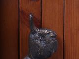a statue of a bird that is on a wooden wall
