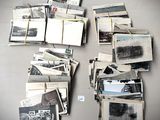 une pile de vieilles photos posée sur une table, à côté d'un bloc-notes