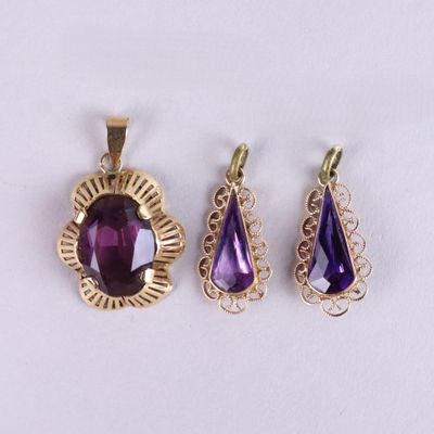 three amethorate pendants and a pendant with a tear shaped amethorate