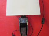 une lampe posée sur une table, avec un mur rouge en arrière-plan