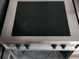 a stainless steel stove top in a kitchen with tile flooring
