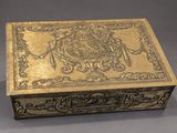 an antique brass box with a decorative design on the lid