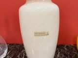 a white vase sitting on a marble table next to a lemon