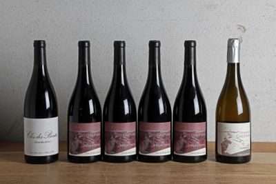 six bottles of wine are lined up on a wooden table