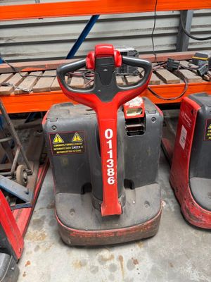 three red and black forklifts sitting in a warehouse