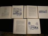 several open books on a table with a drawing of a building