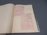 un livre ouvert, sur lequel figure une carte, posé sur une table