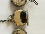 three different types of pocket watches sitting on a table