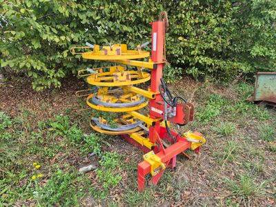 une machine rouge et jaune qui est garée dans l'herbe