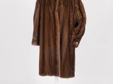 une photo d'un manteau de fourrure marron posé sur un présentoir pour mannequin