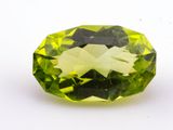 a close up of a green gemstone on a white surface