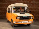 an orange and white van parked in front of a brick wall