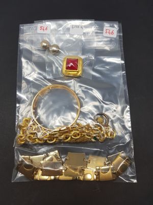 a bag of gold jewelry on a black table