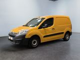 La camionnette jaune est garée dans une pièce blanche au sol noir.