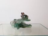 a glass table topped with a figurine of a frog on it
