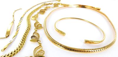 a lot of gold jewelry on a white surface